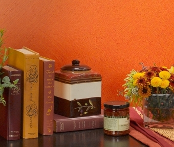 Decor items on a table beside an orange colored wall