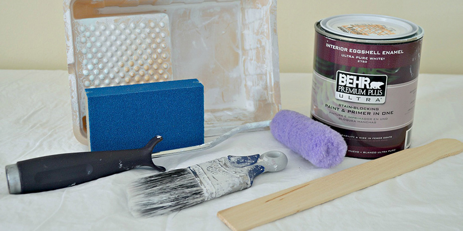 Paint brush, roller, tray, sanding sponge, and a quart of Behr paint