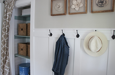 Freshly finished closet alongside a wainscoting wall with coat hangers