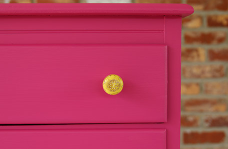 The new yellow hardware looks fabulous against the bold pink dresser
