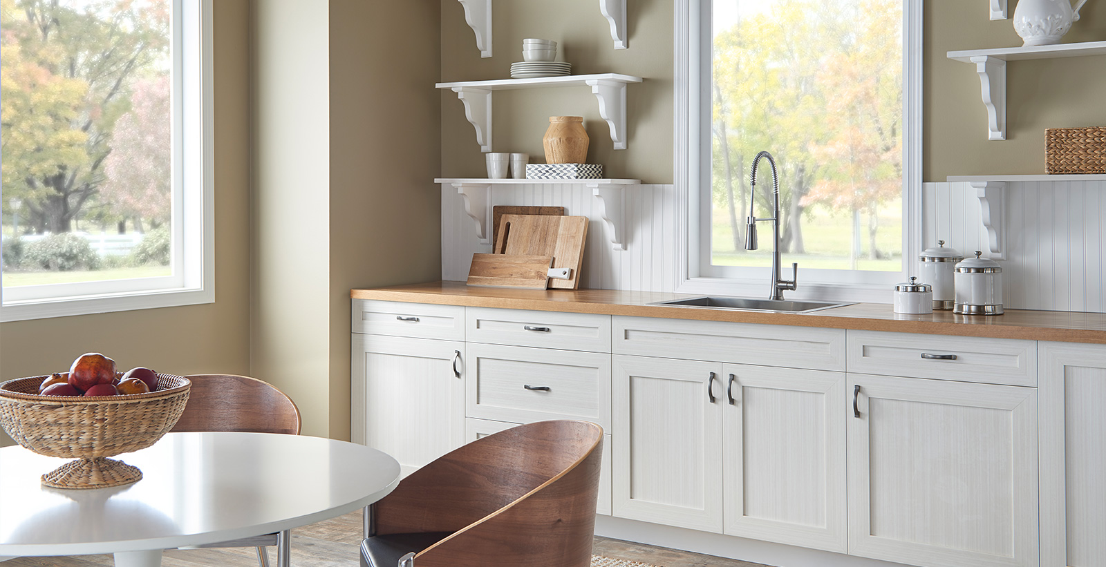 Casual kitchen with tan on wallls, white on cabinets and trim, and wooden counter top