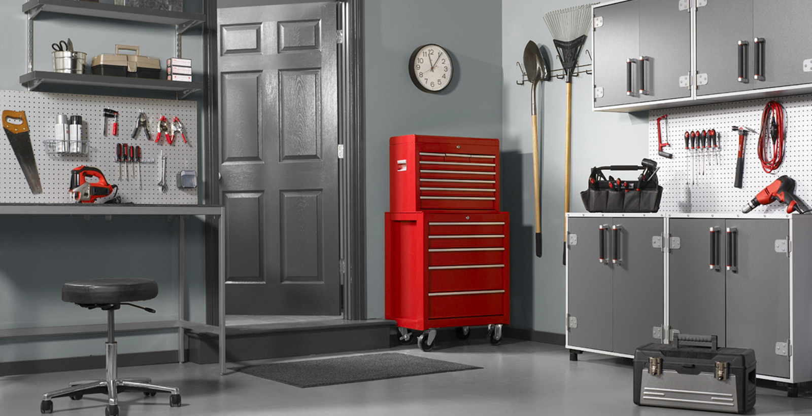 Garage workspace with gray walls and gray trim, red tool chest, versatile and comfortable style.