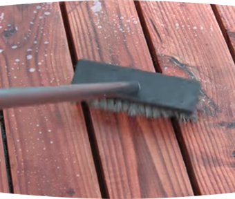 Large brush scrubbing a wood deck