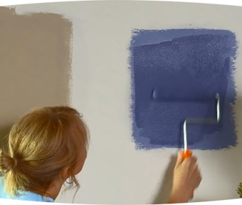Person applying paint to a wall with a paint roller
