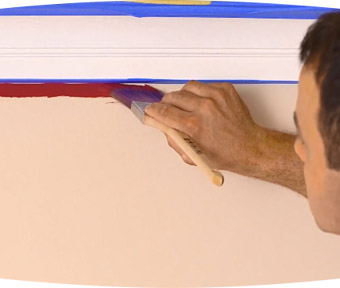 Person using a paint brush to paint under trim