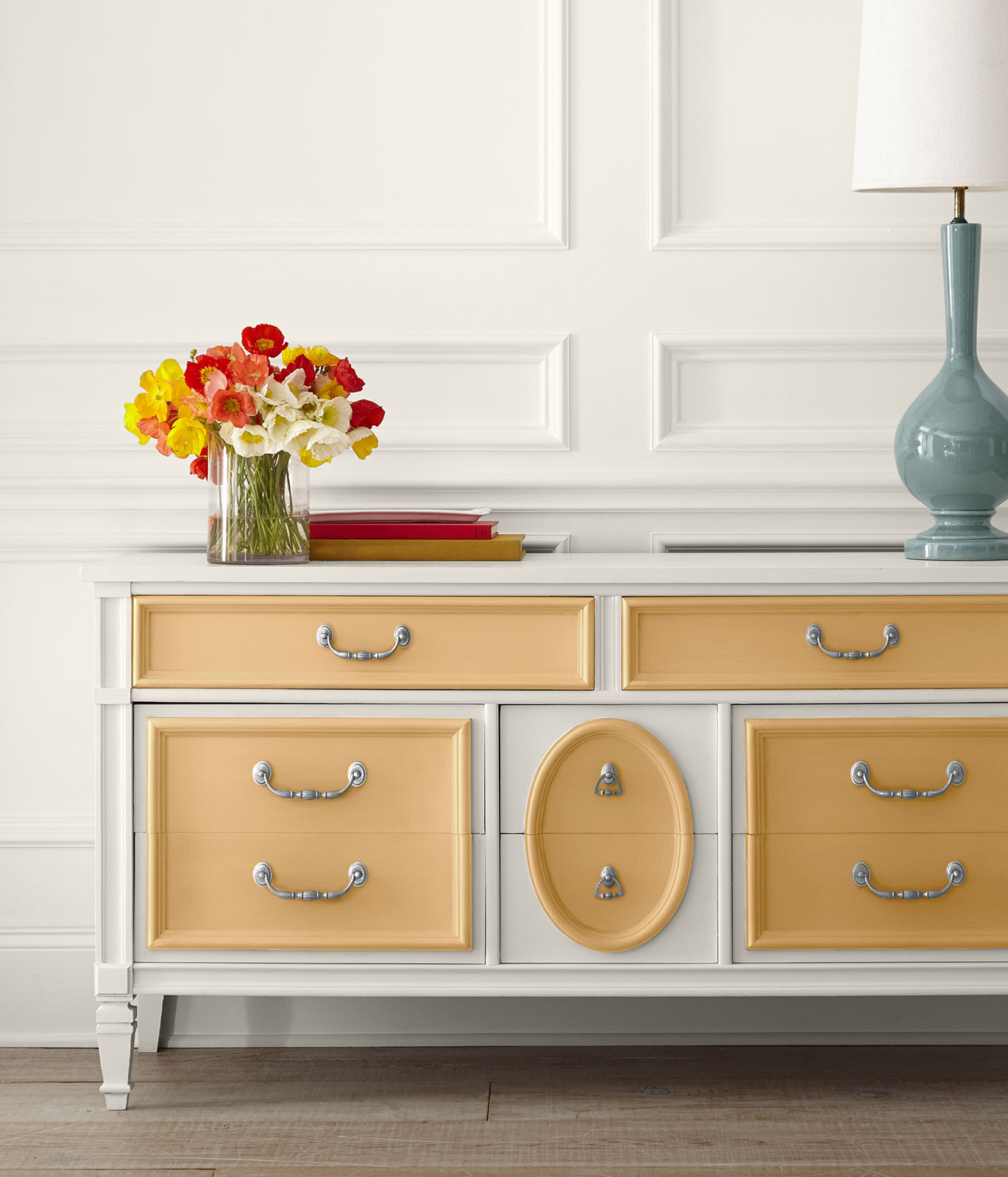 A dresser painted in white. To give a subtle pop of color, the drawer facings are painted in yellow-gold color.