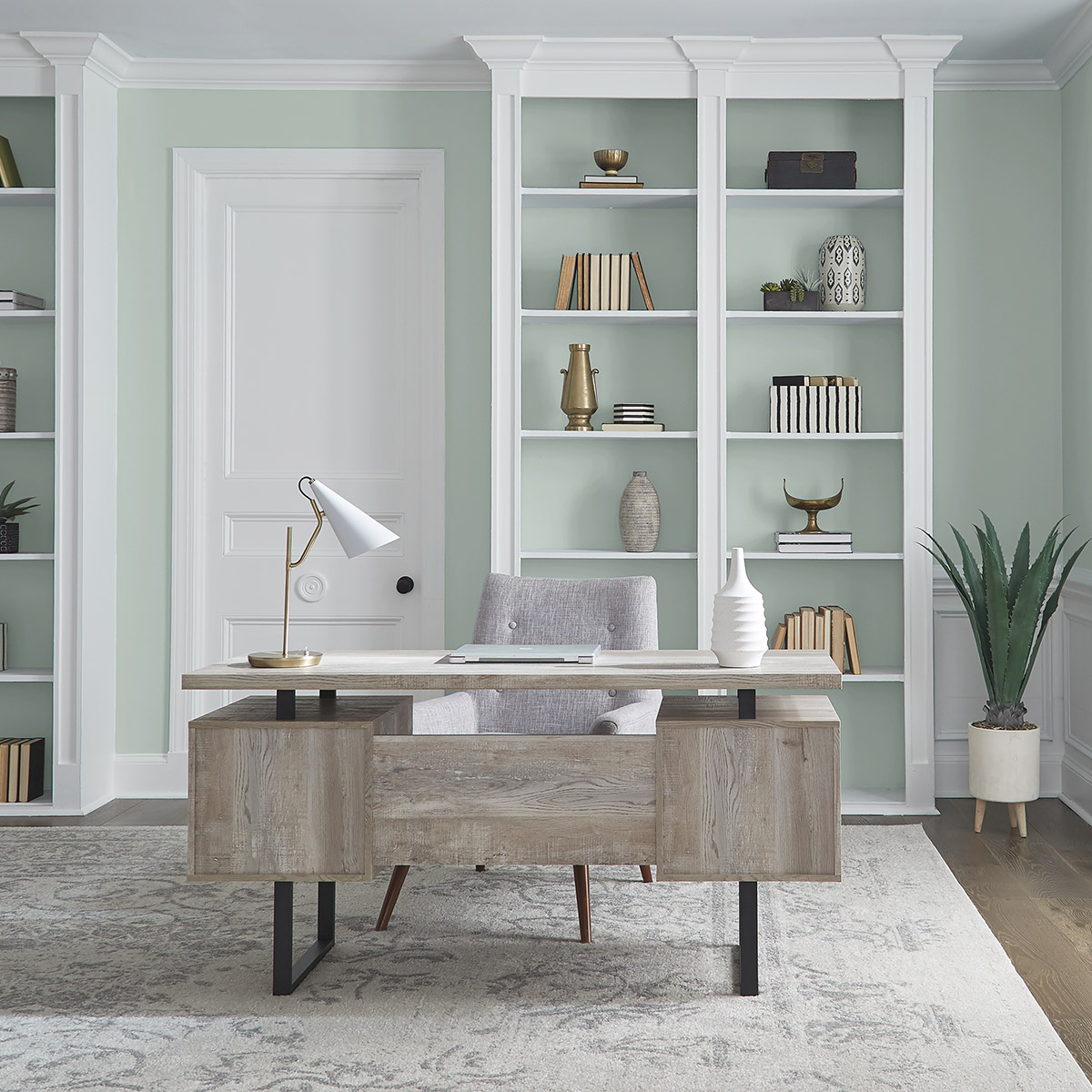 An office with the walls painted in a soft sea glass green hue.